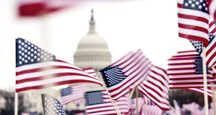 American flags fly in front of the U.S. Capitol building.