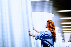 Businesswoman touching a beam of light by hand at the subway station, Shanghai, China